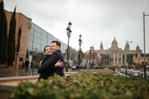 junges schönes liebevolles hispanisches paar geht während des regens unter einem regenschirm spazieren. foto