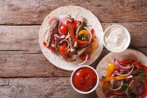 Tortillas mit Fleisch, Gemüse und Soße horizontale Draufsicht