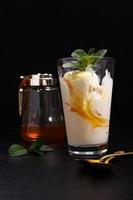 Eis in einem Glas mit Honig auf einer dunklen