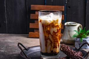 Eisgetränk aus frischer Milch mit braunem Zucker in einem klaren Glas foto