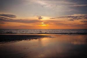 schöner sonnenuntergang über dem strand und dem meer foto