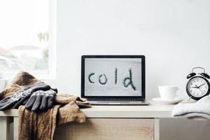 Ein Laptop mit kaltem Schriftzug und Winterzubehör für das Winterhintergrundkonzept foto