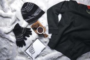kreative flache lage aus pullover, mütze, winterhandschuhen für den hintergrund der wintersaison foto