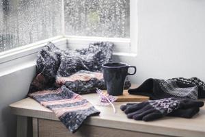 Winterhandschuhe, Mütze und Pullover bei einer Tasse Kaffee zur Begrüßung der Wintersaison foto