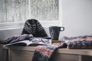 Winterhandschuhe, Mütze und Pullover bei einer Tasse Kaffee zur Begrüßung der Wintersaison foto