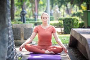 aktive schöne Blondine, die Yoga-Übungen macht und im Freien trainiert. foto