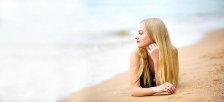 schöne blonde Frau im schwarzen Bikini genießen Sie die Sommerzeit am Strand. foto
