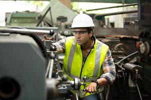 Arbeiter arbeiten auf dem Werksgelände und überprüfen die Maschine in der Produktlinie oder die Produkte vor Ort. ingenieur oder techniker, der material oder maschine in der anlage überprüft. Industrie und Fabrik. foto