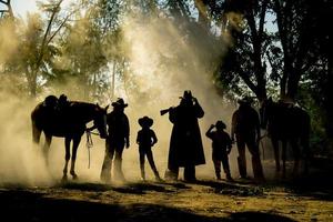 Silhouette Cowboy zu Pferd vor einem wunderschönen Sonnenuntergang, Cowboy und Pferd im ersten Licht, Berg, Fluss und Lebensstil mit natürlichem Lichthintergrund foto