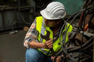 vorarbeiter oder arbeiter arbeiten am fabrikstandort und überprüfen maschine oder produkte vor ort. ingenieur oder techniker, der material oder maschine in der anlage überprüft. Industrie und Fabrik. foto