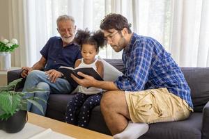 porträt einer glücklichen gemischtrassenfamilie mit kleinen kindern sitzt entspannt auf der couch und kuschelt, die eltern ruhen sich auf dem sofa aus und umarmen vorschulkinder zu hause zusammen foto