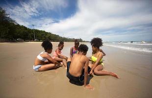 Kinder spielen auf Sand am Strand foto