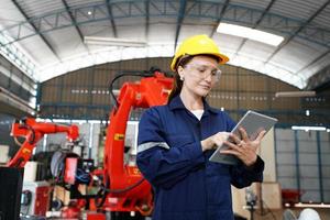 Porträt eines professionellen Ingenieurarbeiters der Schwerindustrie, der Uniform, Brille und Schutzhelm in einer Stahlfabrik trägt. schöne weibliche industriespezialistin, die in einer metallbauanlage steht. foto