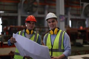 industriearbeiter vorarbeiter oder arbeiter arbeiten am fabrikstandort und überprüfen maschine oder produkte vor ort. ingenieur oder techniker, der material oder maschine in der anlage überprüft. Industrie und Fabrik. foto