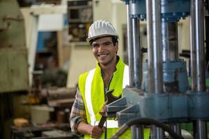 vorarbeiter oder arbeiter arbeiten am fabrikstandort und überprüfen maschine oder produkte vor ort. ingenieur oder techniker, der material oder maschine in der anlage überprüft. Industrie und Fabrik. foto