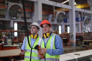 industriearbeiter vorarbeiter oder arbeiter arbeiten am fabrikstandort und überprüfen maschine oder produkte vor ort. ingenieur oder techniker, der material oder maschine in der anlage überprüft. Industrie und Fabrik. foto