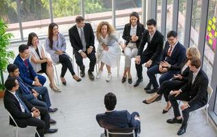 Gruppe von Menschen, die erfahrenen Geschäftsleuten zuhören, die ihnen bei der Ausarbeitung einer neuen Unternehmensstrategie helfen. foto