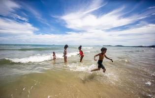 Kinder spielen auf Sand am Strand foto