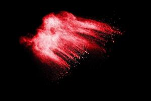 abstrakter roter Staub auf weißem Hintergrund. rote pulverexplosion. einfrieren bewegung roter partikel spritzen. foto