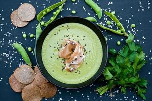 gesunde grüne Suppe mit Schinken und Erbsen