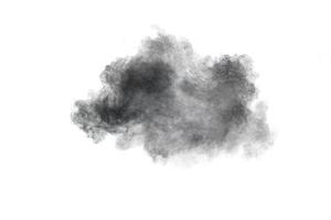 schwarzes pulver explodiert. die partikel von holzkohle spritzen auf weißem hintergrund. foto