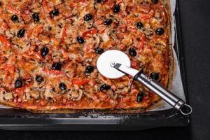 hausgemachte Gemüsepizza mit Tomaten, Oliven und Kräutern foto