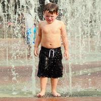 unglückliches Kind in Wasserfontänen foto