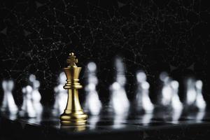 goldene Königsschachbegegnung mit silbernem Schachfeind auf dunklem Hintergrund und Verbindungslinie für Strategieidee und futuristisches Konzept foto