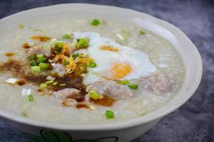 Congee, Reisbrei mit gehacktem Schweinefleisch, gekochtes Ei, ideal zum Frühstück. foto