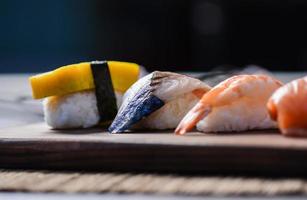 Mischen Sie Sushi auf Holzgericht, Thunfisch, Lachs, Wolfsbarsch, süßes Ei, Garnelen-Sushi, japanisches Essen foto