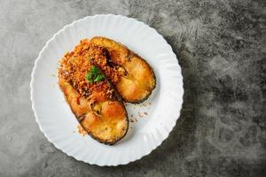 Frittierter Pangasius-Fisch mit schwarzem Pfeffer, Knoblauch und Fischquelle, schnelles und einfaches Gericht. foto