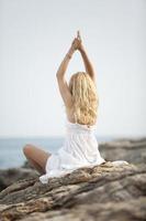 Frau, die Yoga am Strand praktiziert