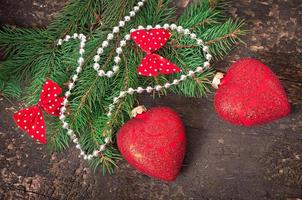 weihnachtsschmuck und tannenzweige auf dem alten hölzernen hintergrund foto