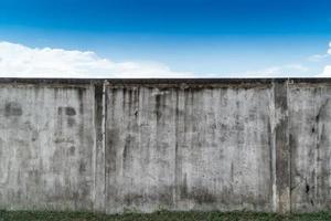 alte rissige graue zement- oder betonwand mit blauem himmel als hintergrund. Grunge verputzter Stuck strukturierter Hintergrund. foto