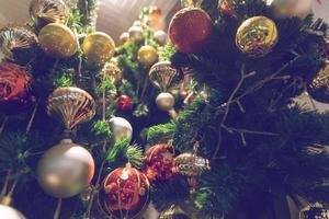 Kugel, die an einem geschmückten Weihnachtsbaum hängt. Unschärfe und Retro-Filtereffekt. foto
