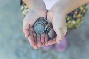 Münze in Kinderhand. Geschäfts- und Finanzkonzept foto