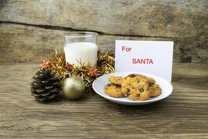 Kekse und ein Glas Milch mit einer weißen Note für Santa foto