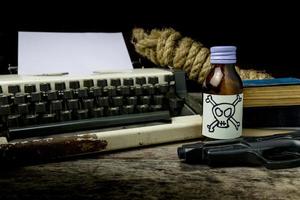 Schreibmaschine mit Papierseite und Gift und Waffe. Konzeptautor Romance Suspense foto