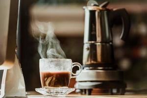 kaffeetasse mit vintage kaffeemaschine moka pot hintergrund auf holztisch im büro zu hause foto