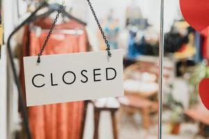 geschlossenes schild, das an der glastür vor dem modebekleidungsgeschäft in bangkok hängt foto