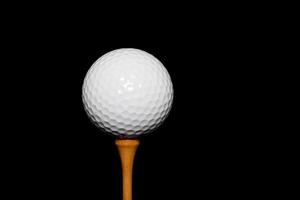 Golfball auf Abschlag auf schwarzem Hintergrund