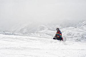 Snowboarder sitzen oben auf dem Berg foto