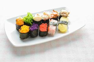 sushi auf weißem teller, thunfisch, lachs, wolfsbarsch, süßes ei, garnelensushi, japanisches essen foto