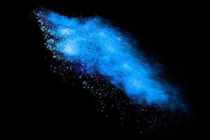 blaue pulverexplosionswolke auf schwarzem hintergrund. gestartete blaue staubpartikel spritzen. foto
