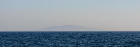 einsame Vulkaninsel weit über dem Wasser. foto