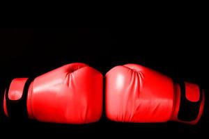 Rosa Boxhandschuh beim Stanzen auf schwarzem Hintergrund im Frauenkonzept foto