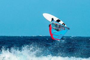 Windsurfer macht einen akrobatischen Sprung über die Wellen foto