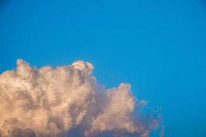 Weiße Kumuluswolken reflektieren das Abendsonnenlicht auf blauem Hintergrund, mehr als der Raum eines Bildes, natürlich abstrakt. foto