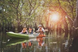 asiatische Familie, die Seekajak im Mangrovenwald segelt foto