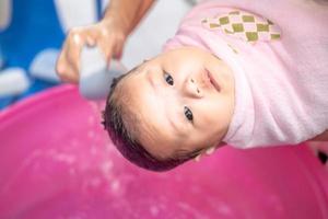 asiatische mutter dusche baby zum reinigen von schmutz geben kind im bad behälter für sauberkeit lebensstil familie zwischen mutter und kind verwendet für babydusche cremeprodukte shampoos lotionen und babypflegeprodukt foto